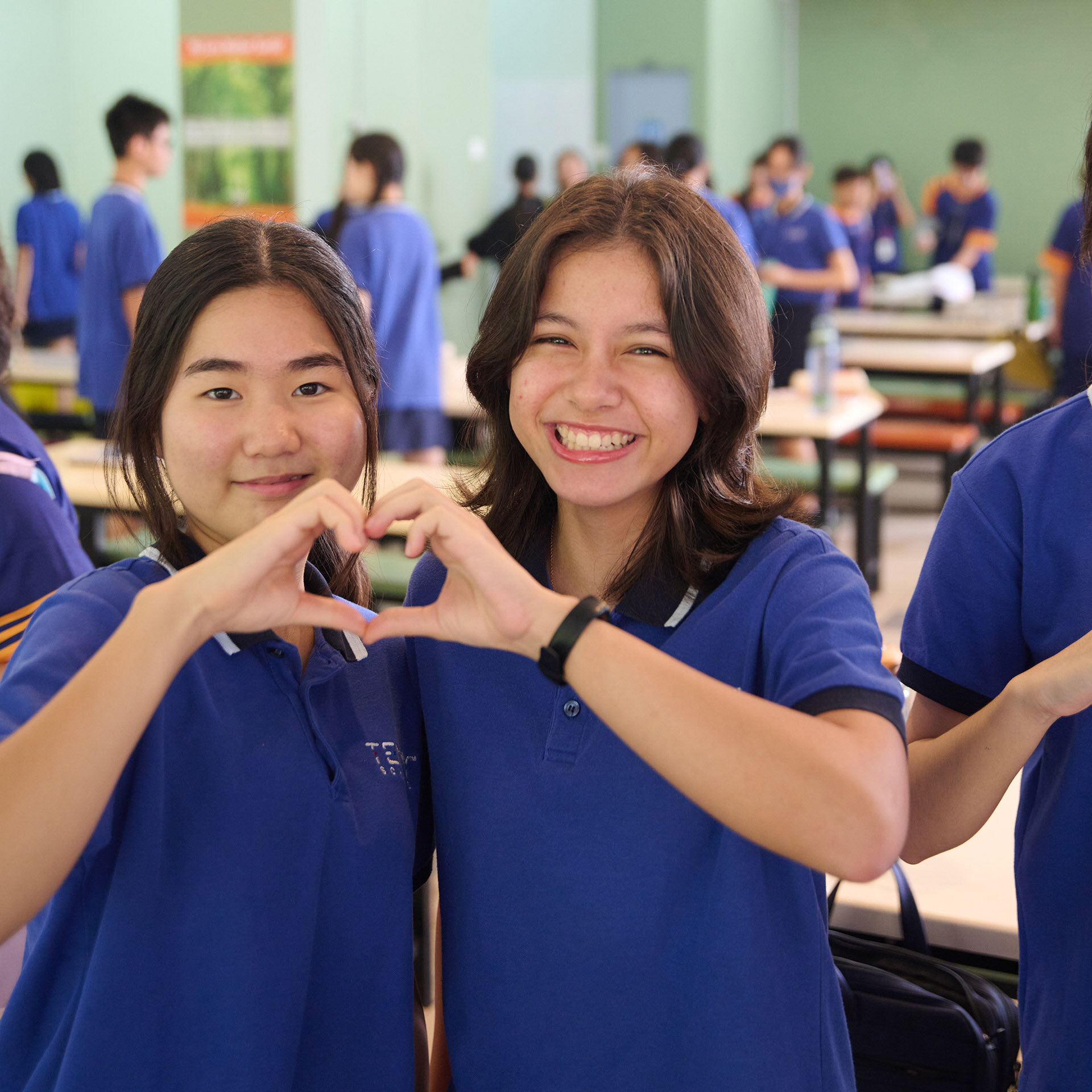 Girl smiling and making a heart with their hands