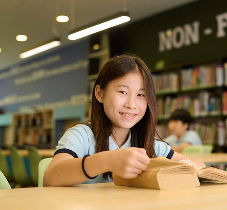 Girl smiling while reading a book