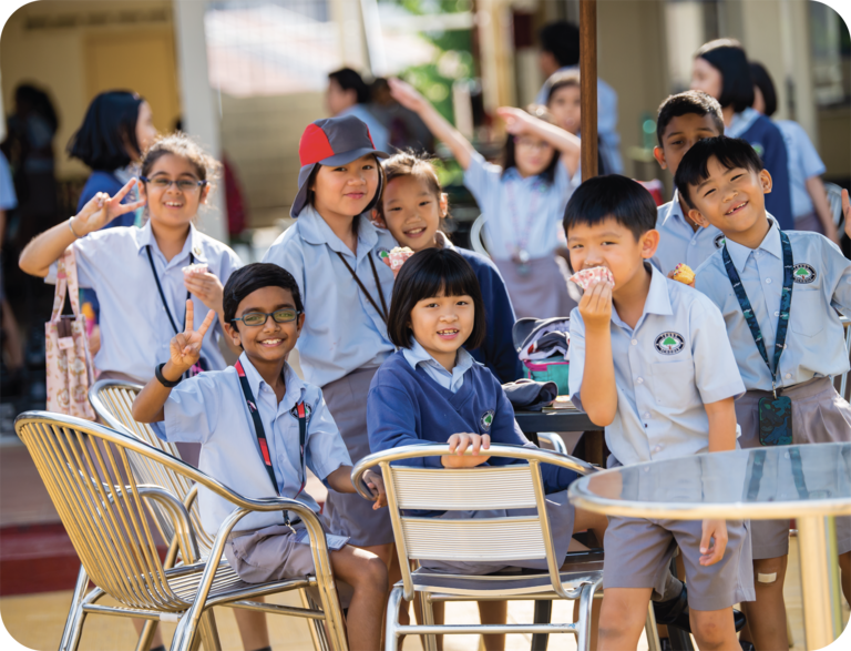 Young students smiling while sitting at a table