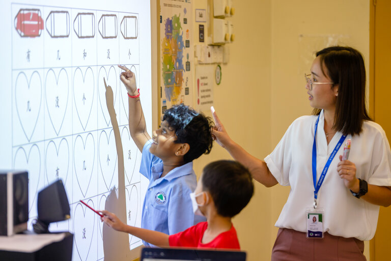 Young student smiling and learning with her teacher