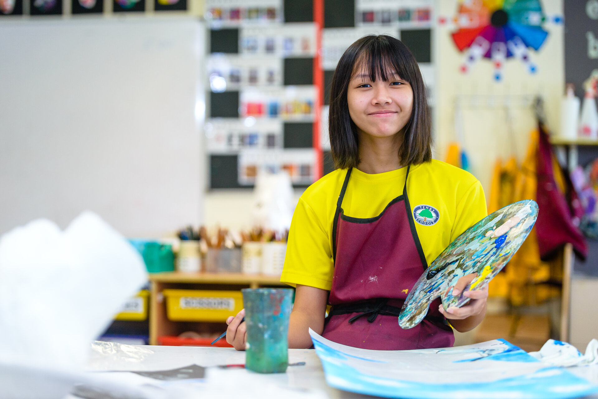 Tenby Schools student smiling while painting