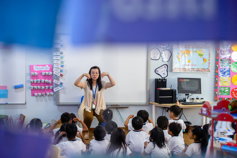 Teacher doing hand gestures in front of her students