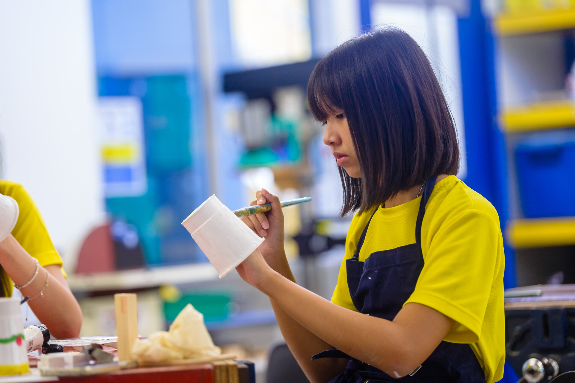 Girl painting a cup