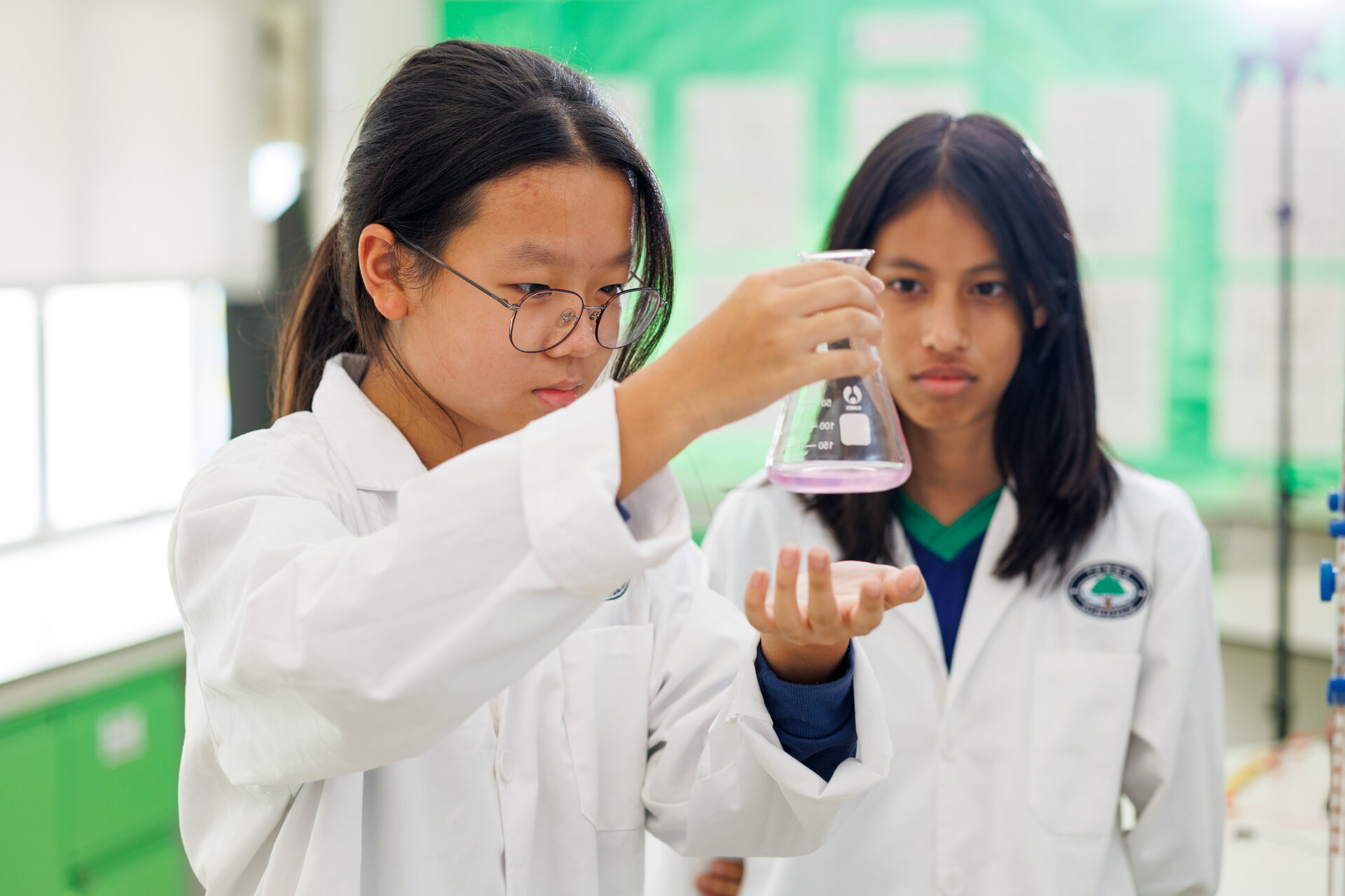 Girls looking at a beaker