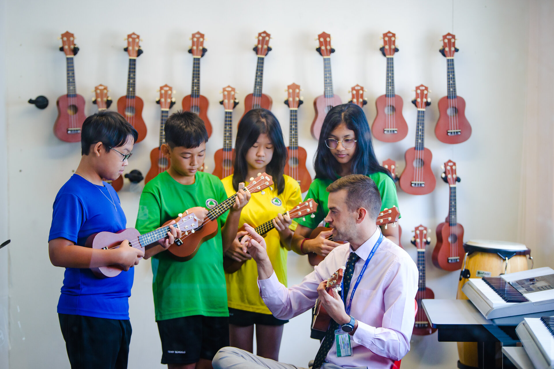 Students playing guitars with their teacher
