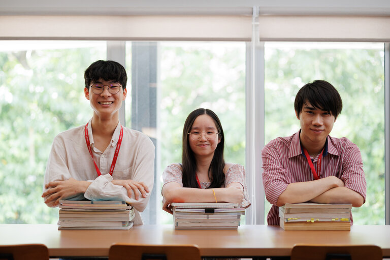 Students with their hands crossed over piles of books
