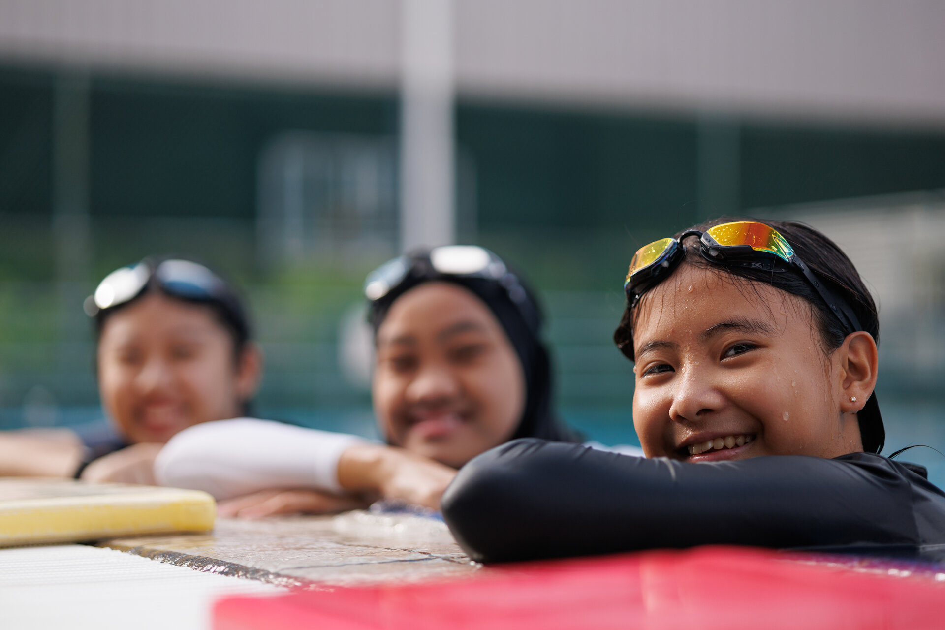 Girls in a swimming pool smiling